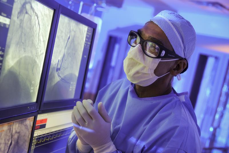 A surgeon at AHS Carrolwood studies a patient's imaging in the operating room, preparing for a procedure