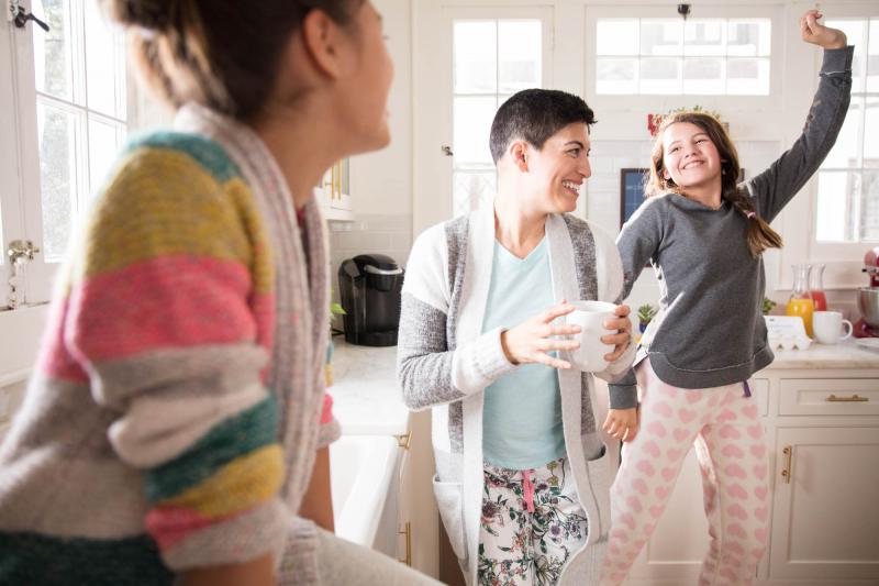 Family dancing in kitchen during breakfast.