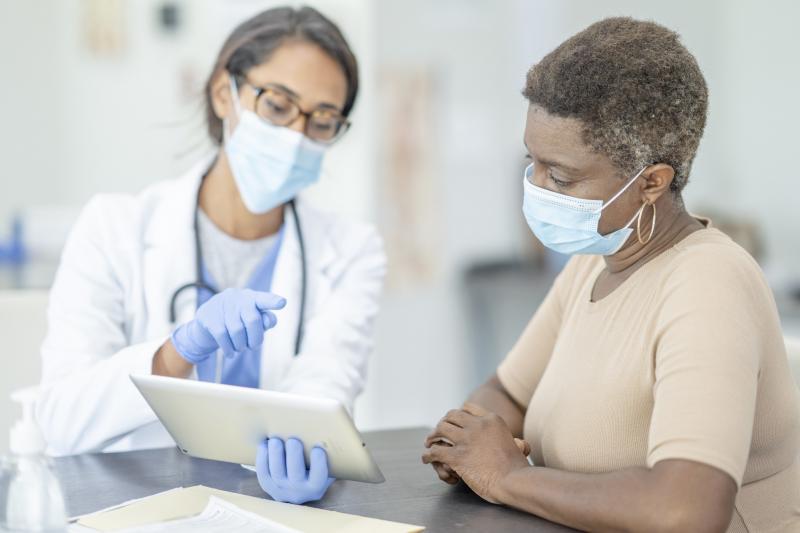 A woman at the doctor wearing a mask.