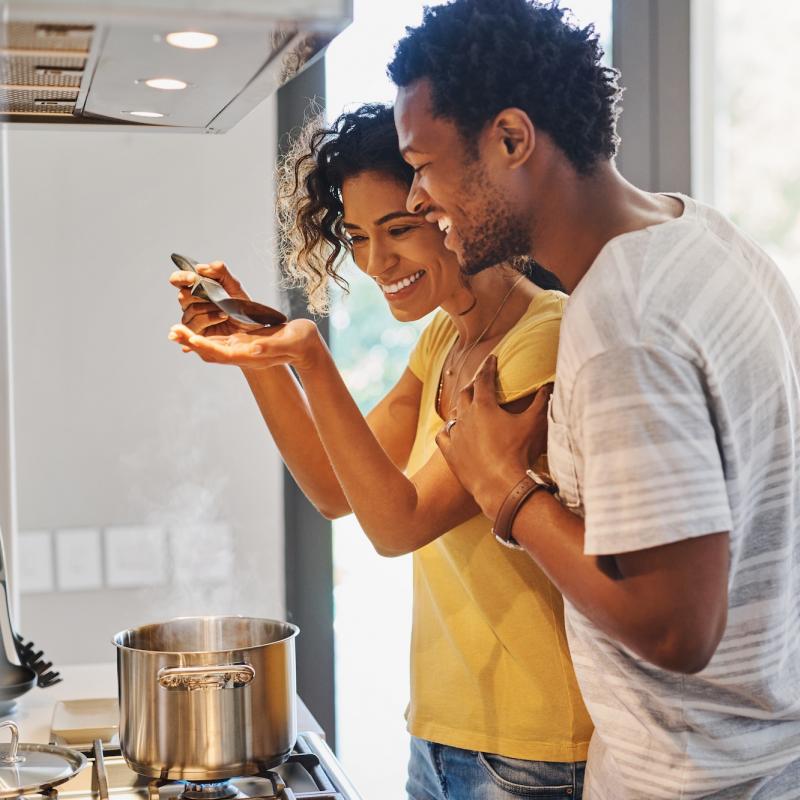 A young couple cooking in their kitchen at home.
