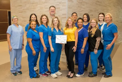 Group of team members posing together to display an award