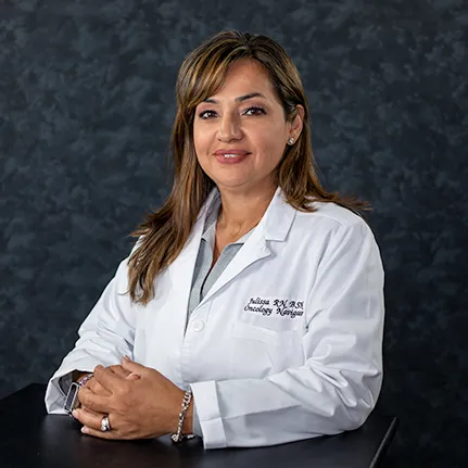 Nurse navigator posing for a headshot with her white coat on