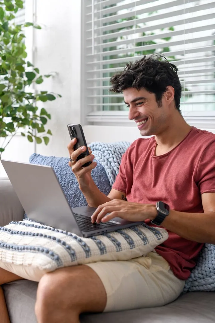 Man looking at his phone while sitting on a sofa