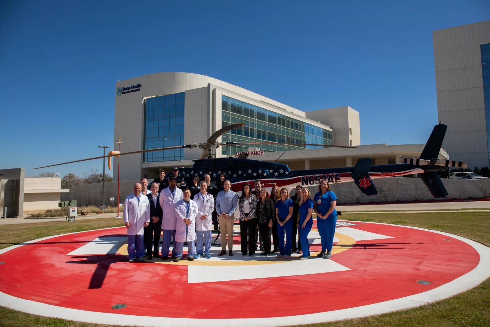 Texas Health Huguley team members and EMS workers standing in front of a helicopter in front of the THH ED